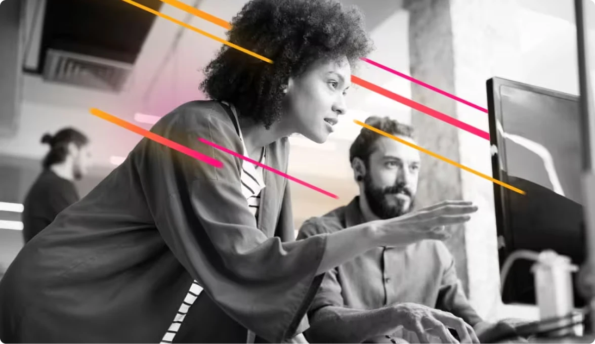 Black and White image of two people looking at a monitor