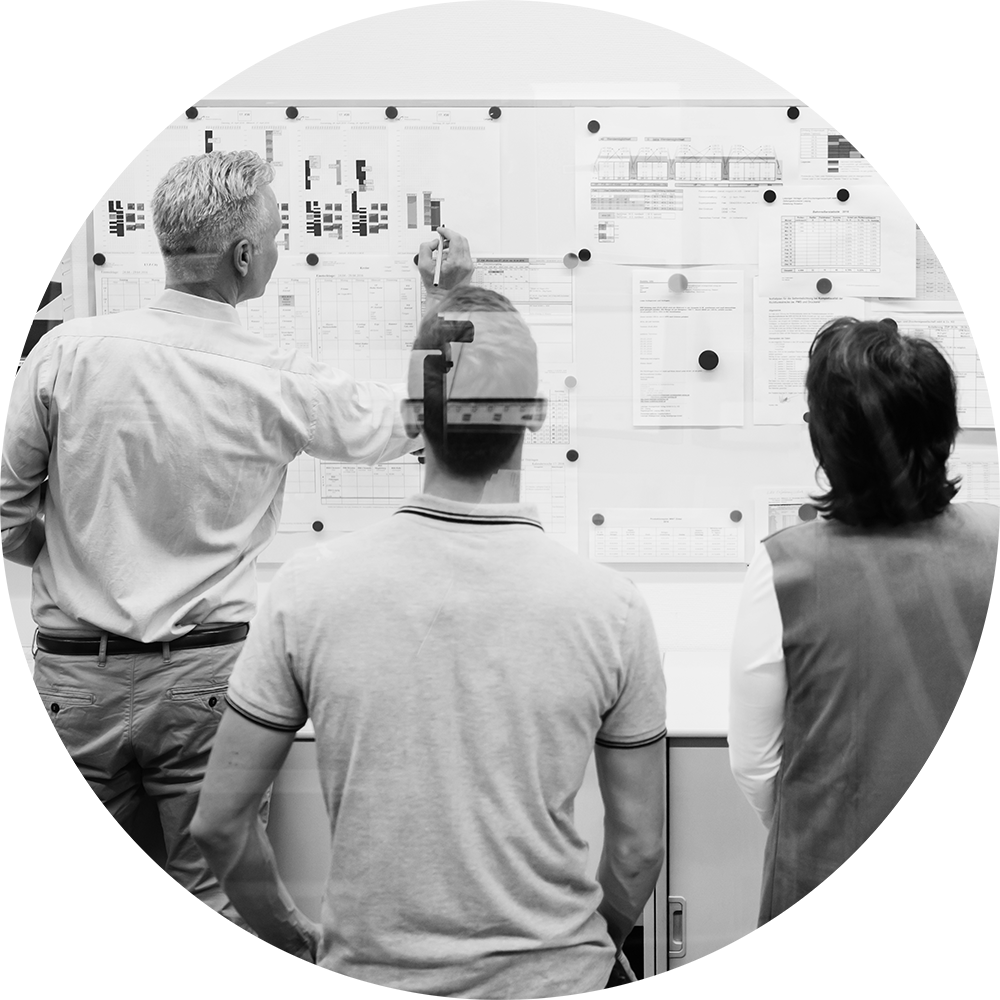 A group of people looking at a white board.