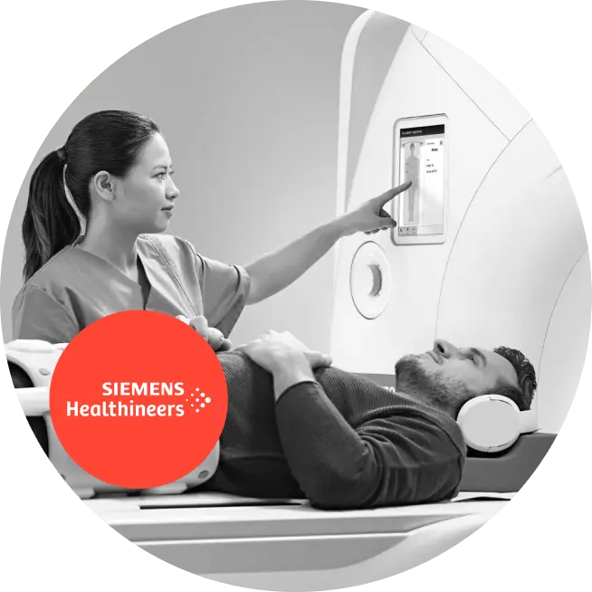 A man lying on a bed with a nurse pointing at the screen, discussing monetization solutions.