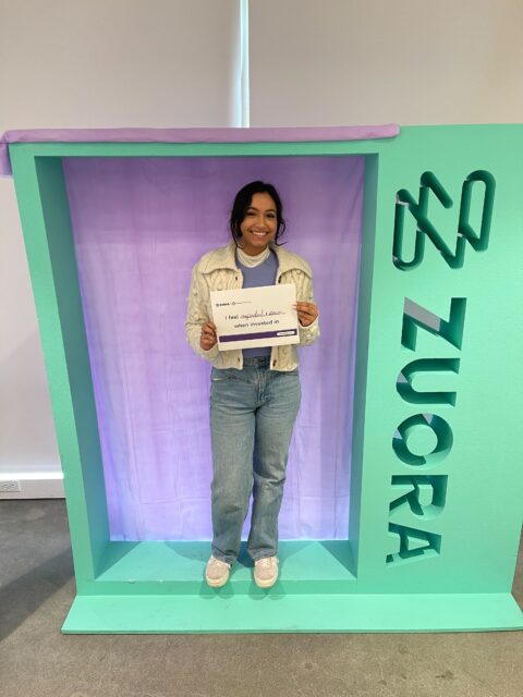A woman standing in front of a purple box.