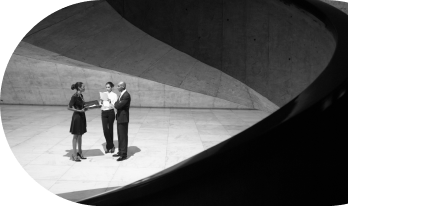Two individuals engaged in a conversation while standing on a curved concrete surface, with shadows casting across the scene.