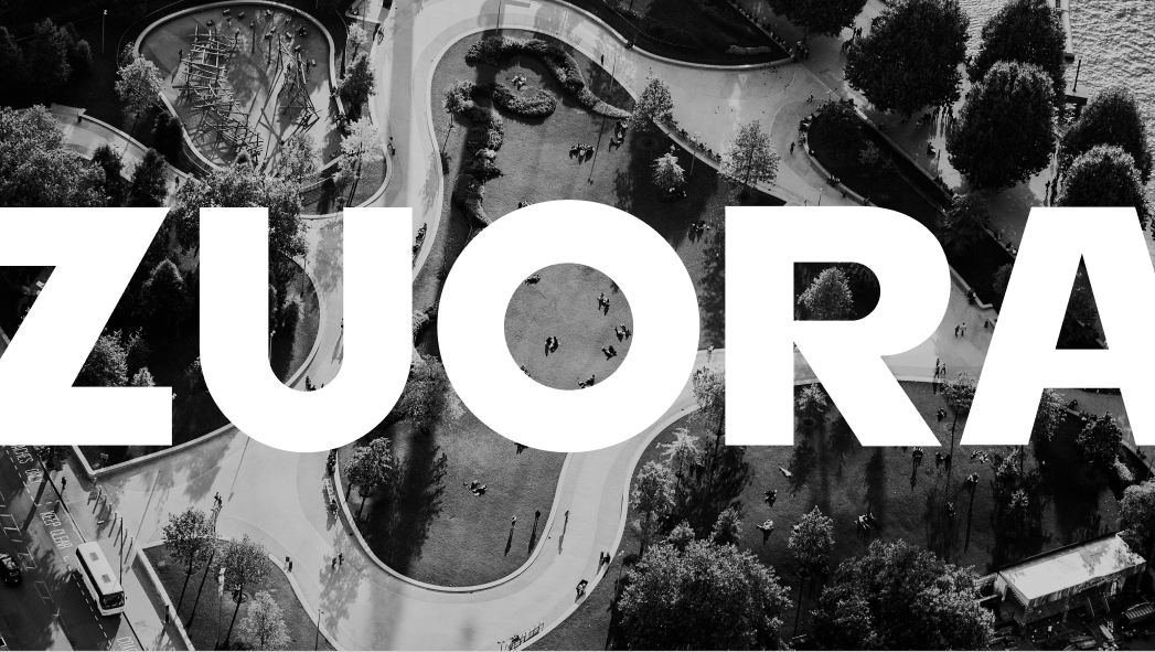 Aerial view of a park with curved paths and trees, overlaid by large bold white text reading "ZUORA.