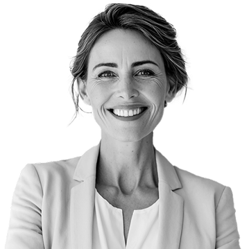 A woman with light hair in a blazer smiles at the camera against a plain background.